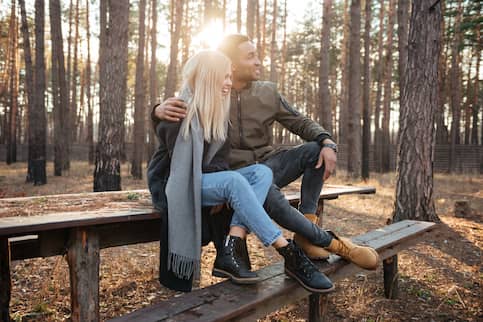 Couple sitting on a picnic table and looking at vacation home.