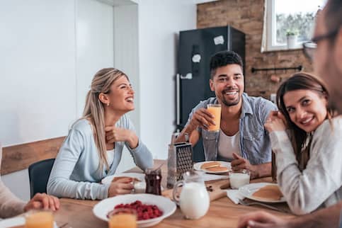 group of roommates having breakfast at home together