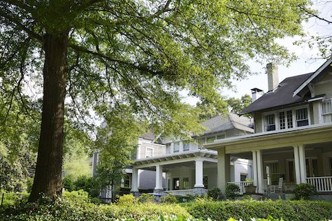 Row of gray houses with trees.