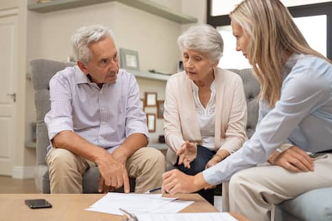 Senior couple consulting their estate agent.