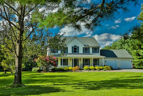 Single Family Home with green grass and tree out front