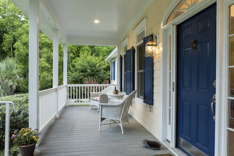 White front porch with dark blue door and shutters