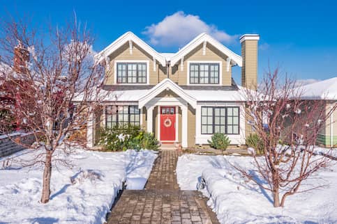 Tan Home With Red Door In Winter