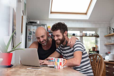 Tattooed Couple On Laptop In Kitchen