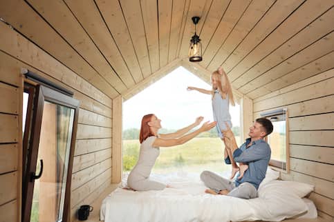 family in loft of tiny home with large window