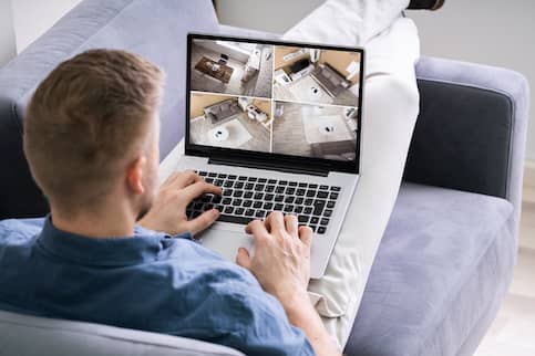 Man on laptop viewing virtual house tour.