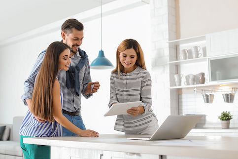 Couple discussing documents with real estate agent.