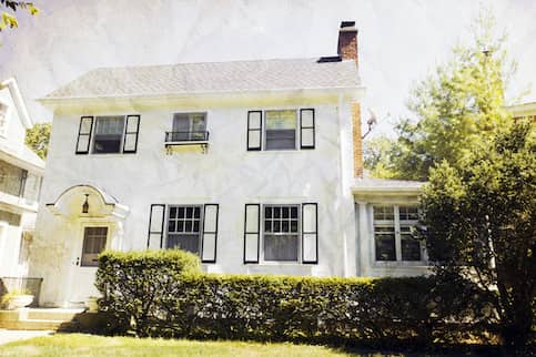 White stucco home with all seasons room.