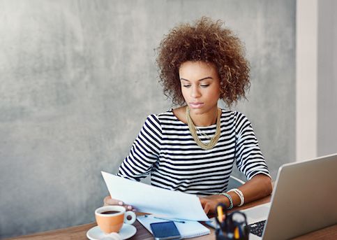 Woman looking at papers at a desk. 