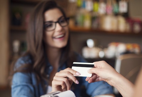 Young woman paying at a store using her credit card.