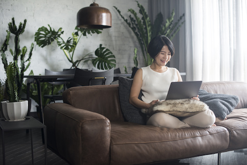 woman sitting in couch while on laptop