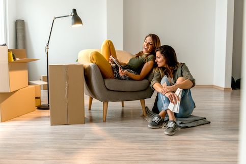 Women moving into new a house, picking out paint colors.