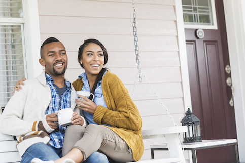 Couple drinking coffee or tea on porch.