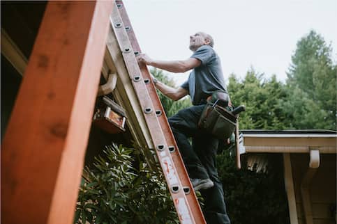 Worker assessing roof repairs.