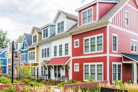 A colorful row of houses along in a row in a nice neighborhood.