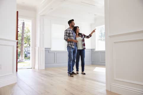 Young couple house hunting together in a home entryway.