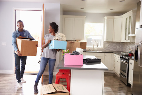 Young couple moving into new house with boxes.