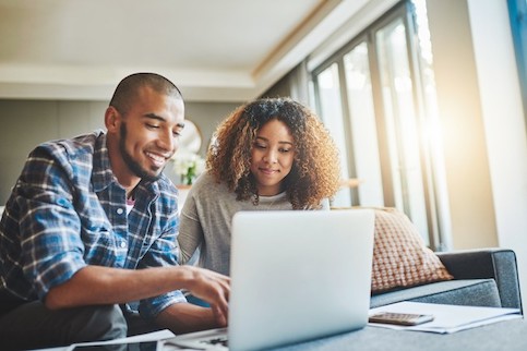 Couple using laptop together in their home.