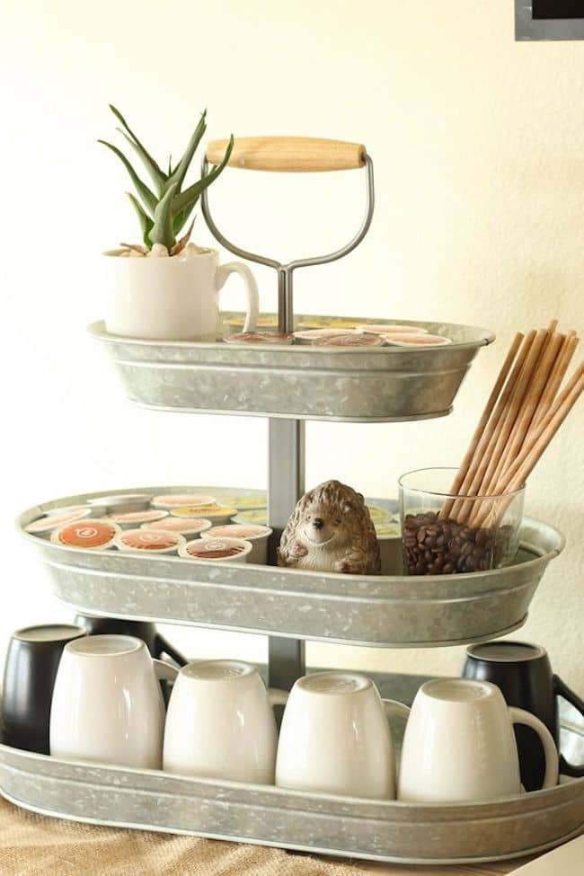 Three tiered serving tray holding mugs and coffee.