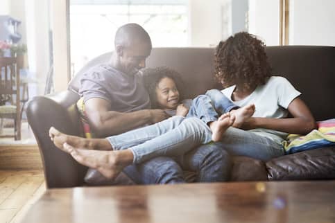 Family of three relaxing on their couch.
