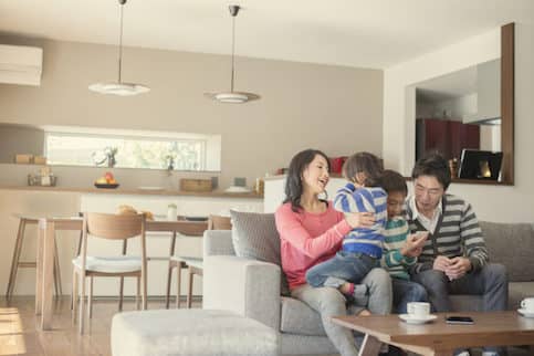 Family sitting on the couch together in their home.