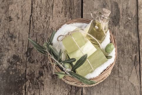 Wooden gift basket holding green soaps.