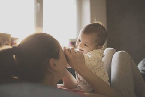 Mom playing with her baby at home.