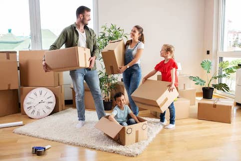 Happy family moving into new house with many boxes.