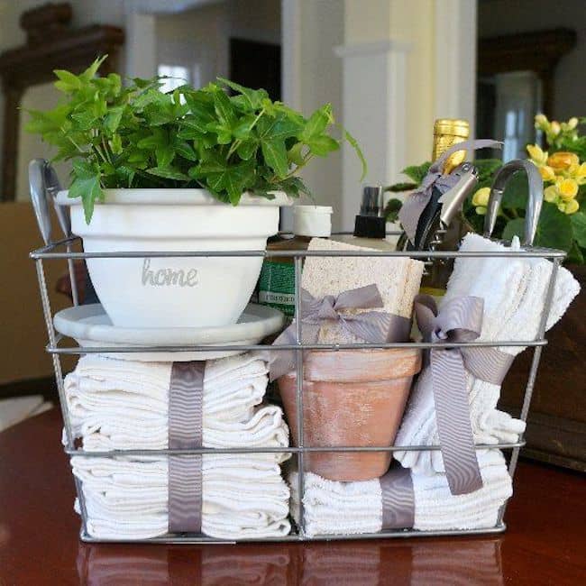 Bathroom gift basket containing towels and a small potted plant.