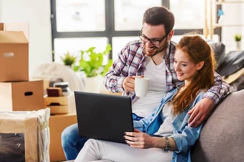 Young couple on couch in newly moved in home.