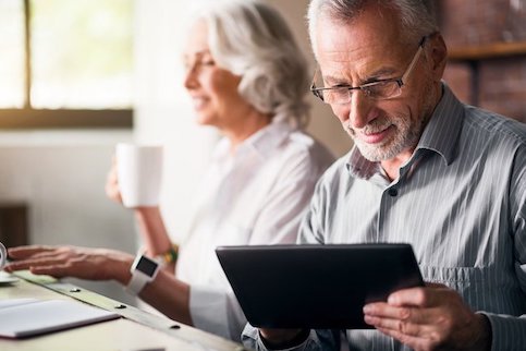 Older couple working side by side in office.