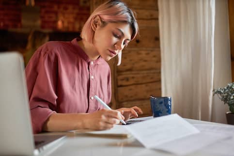 young white woman with pink hair with calculator