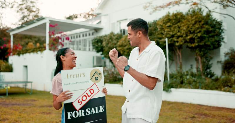 man celebrates buying his first home