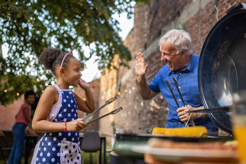 grandfather and granddaughter hi-five at cookout
