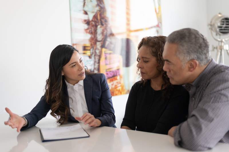 A loan officer reviews mortgage options with an older couple.